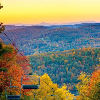 A chairlift over the fall trees and mountains (Instagram@mohawkmtn)