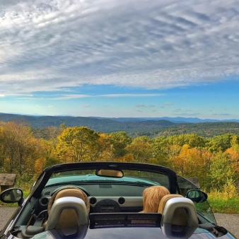 A woman in parked car looking out at mountain view (Instagram@mrtimmyc)