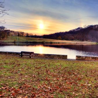 A sunset over the pond and fall leaves on the grass (Flickr@Sunday-Drive)