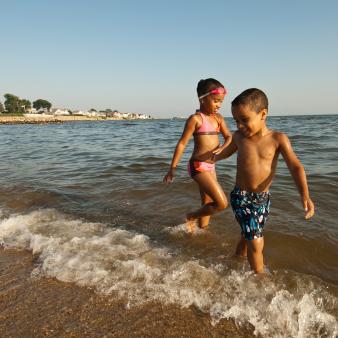 Two kids playing on the shoreline at Rocky Neck State Park