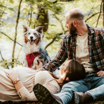 A couple relaxing with their dog in the woods (Instagram@hvhfotographic)