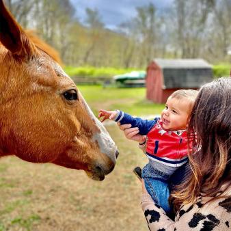 A mom and her son petting a horse (Instagram@irafi71)