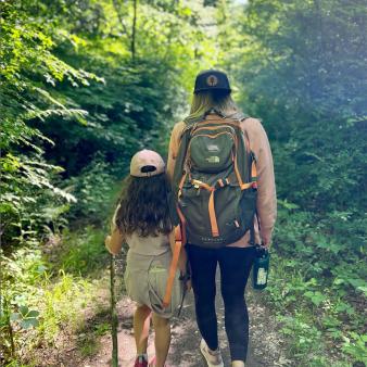 A mom and daughter on a hike through the woods (Instagram@outdoorwiseliving)