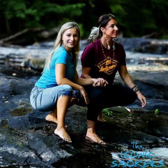 Dos mujeres cogidas de la mano sobre una roca en el río (Instagram@hotvle22)