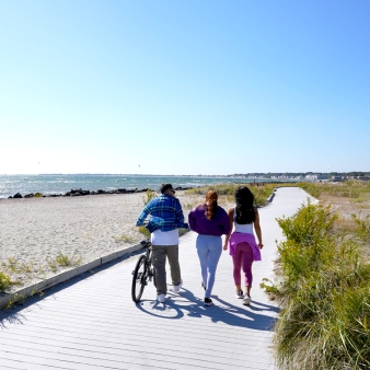 Friends walking along boardwalk at Silver Sands State Park 