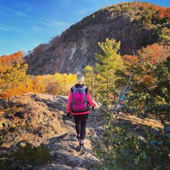 Woman hiking up Sleeping Giant in Fall (Instagram@thefarthershegoes)