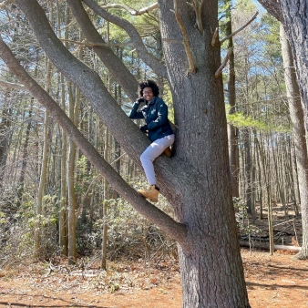 Mujer trepando un árbol en West Rock Ridge (Instagram@naturally.mesha)