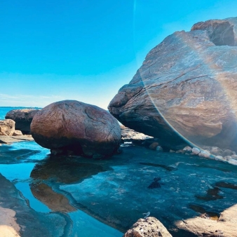 Llamarada solar sobre la línea de playa rocosa en Bluff Point (Instagram@shark_bait_cait)