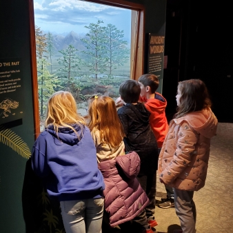 Niños observando la exhibición en el Dinosaur State Park