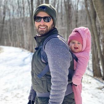 A father hiking in the snow with baby girl on his back (Instagram@time06)