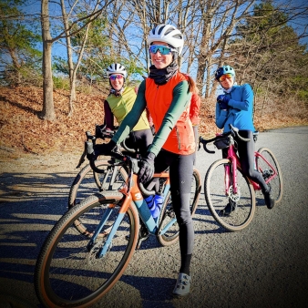 Tres mujeres andando en bicicleta juntas en un día soleado de otoño.