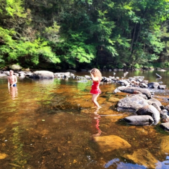 Dos niños pequeños jugando en el agua en un día soleado.