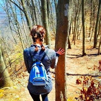 Una mujer con mochila disfrutando de la naturaleza en una ruta de senderismo.