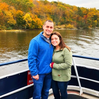 A couple enjoying a boat ride during autumn.