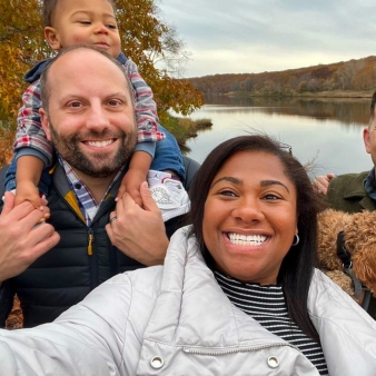 Familia sonriendo junto al agua.