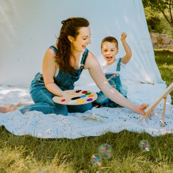 Una mujer y un niño pintando en un campo de hierba.