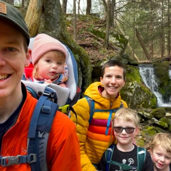 Una familia feliz disfrutando de una caminata invernal por el bosque.