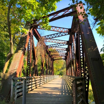 A bridge with a metal frame and a wooden walkway.