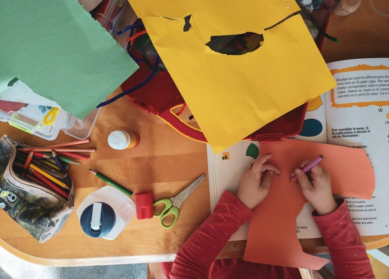 Una vista aérea de las manos de un niño haciendo manualidades.