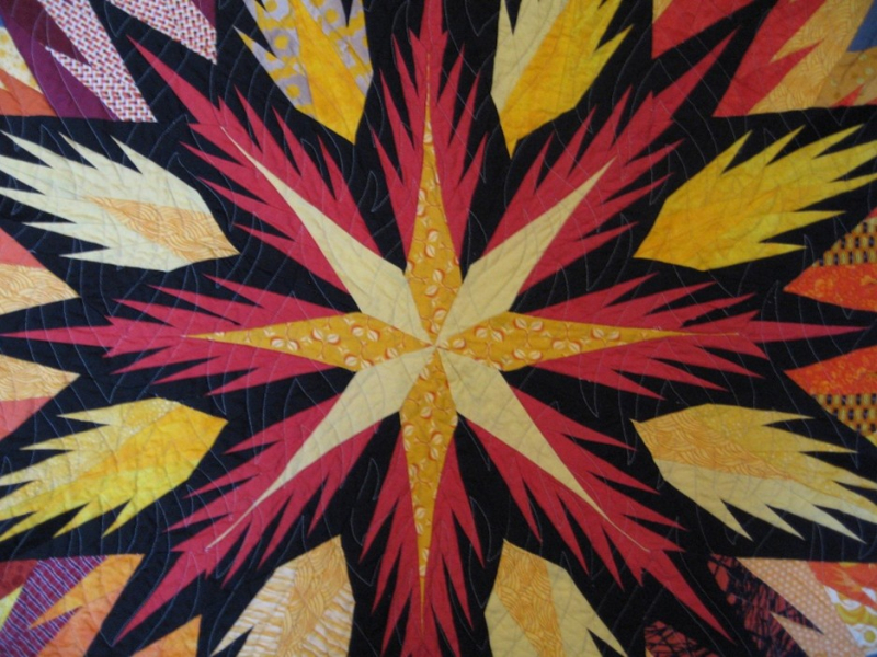 Imagen de una colcha roja, amarilla y negra.