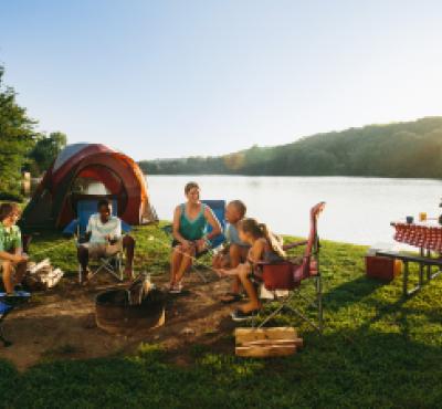 Family camping and picnicking along water in Mystic Country