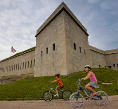Dos niños montando en bicicleta frente a Fort Trumbull, New London