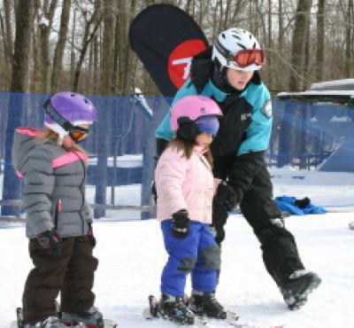Niños aprendiendo a esquiar en Powder Ridge en invierno