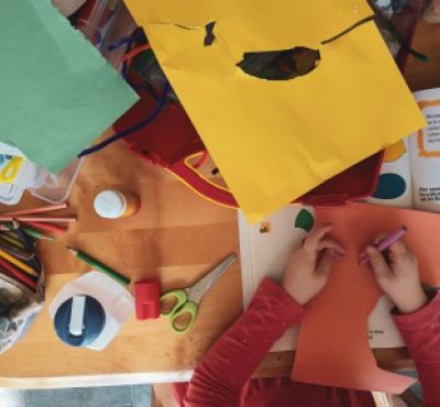 Una vista aérea de las manos de un niño haciendo manualidades.