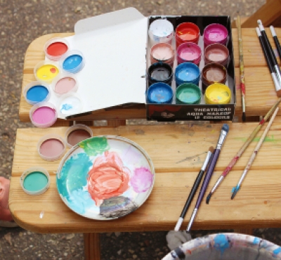 A paint set and paint brushes on a wooden table
