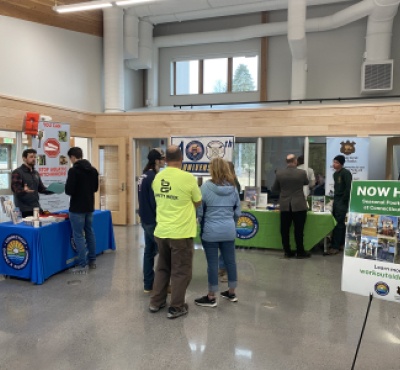 El personal de DEEP habla con candidatos potenciales en un evento de feria de empleo