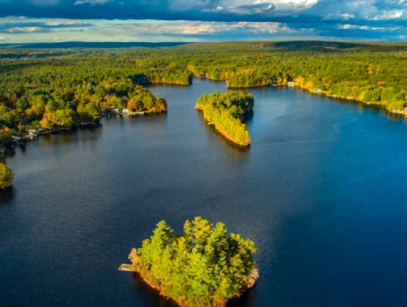 A serene lake nestled amidst lush greenery pictured from above.