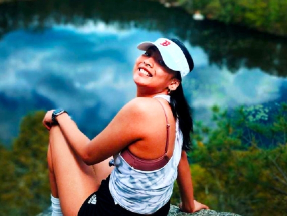 Una mujer disfrutando de la vista de un estanque mientras está sentada en un mirador panorámico.